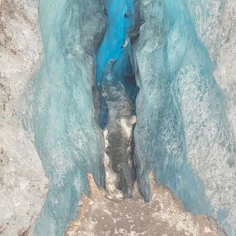 A blue meltwater crevasse on the glacier