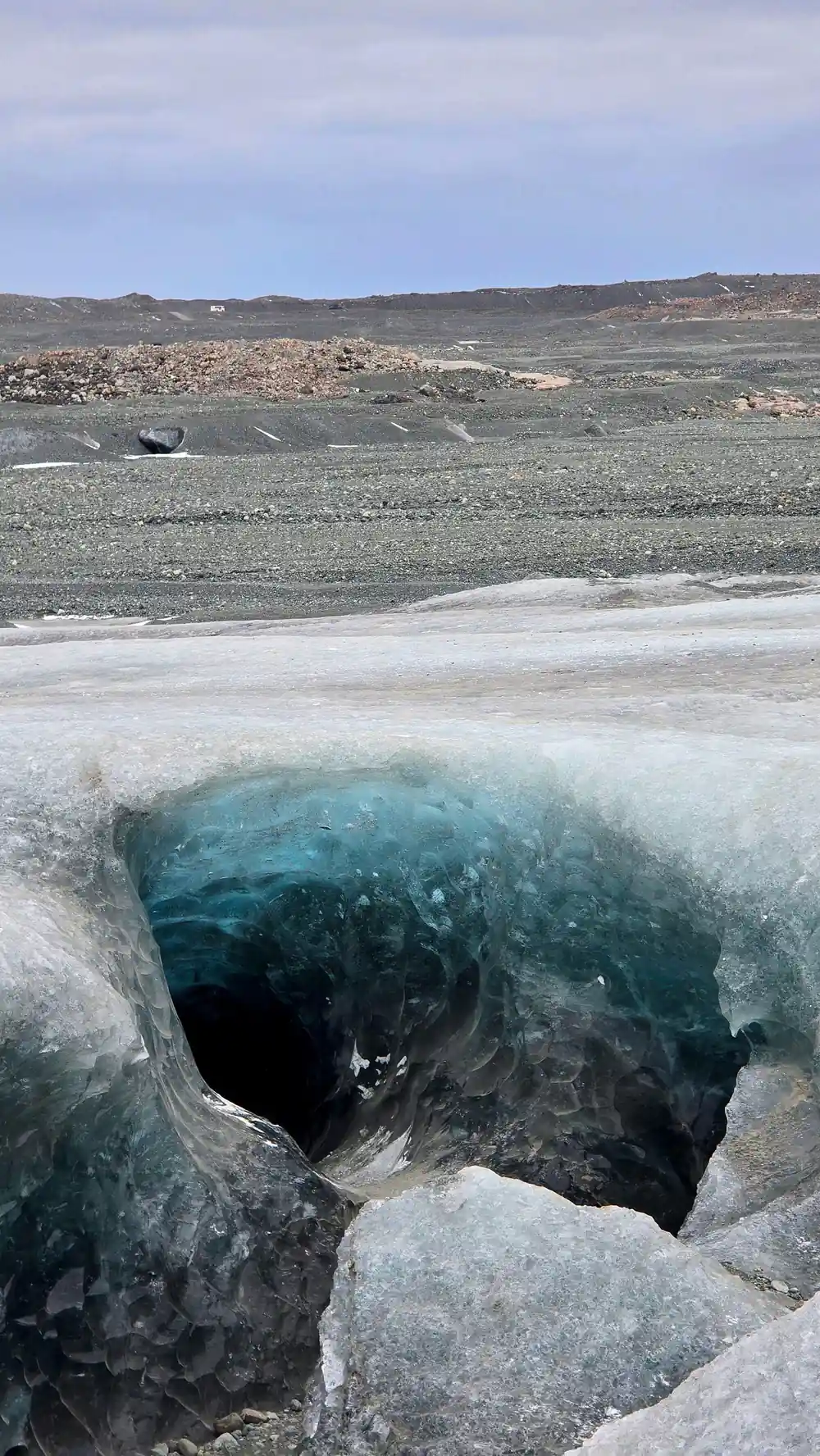 Glacial cave entrance from outside with turquoise opening