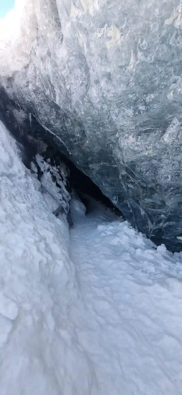 Ice cave entrance with snow and frozen rock walls