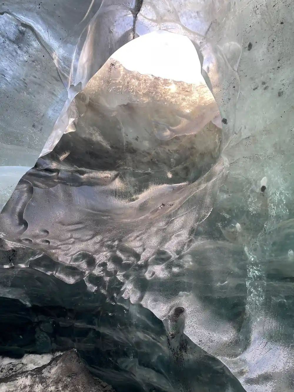 Ice cave interior with hole showing daylight above