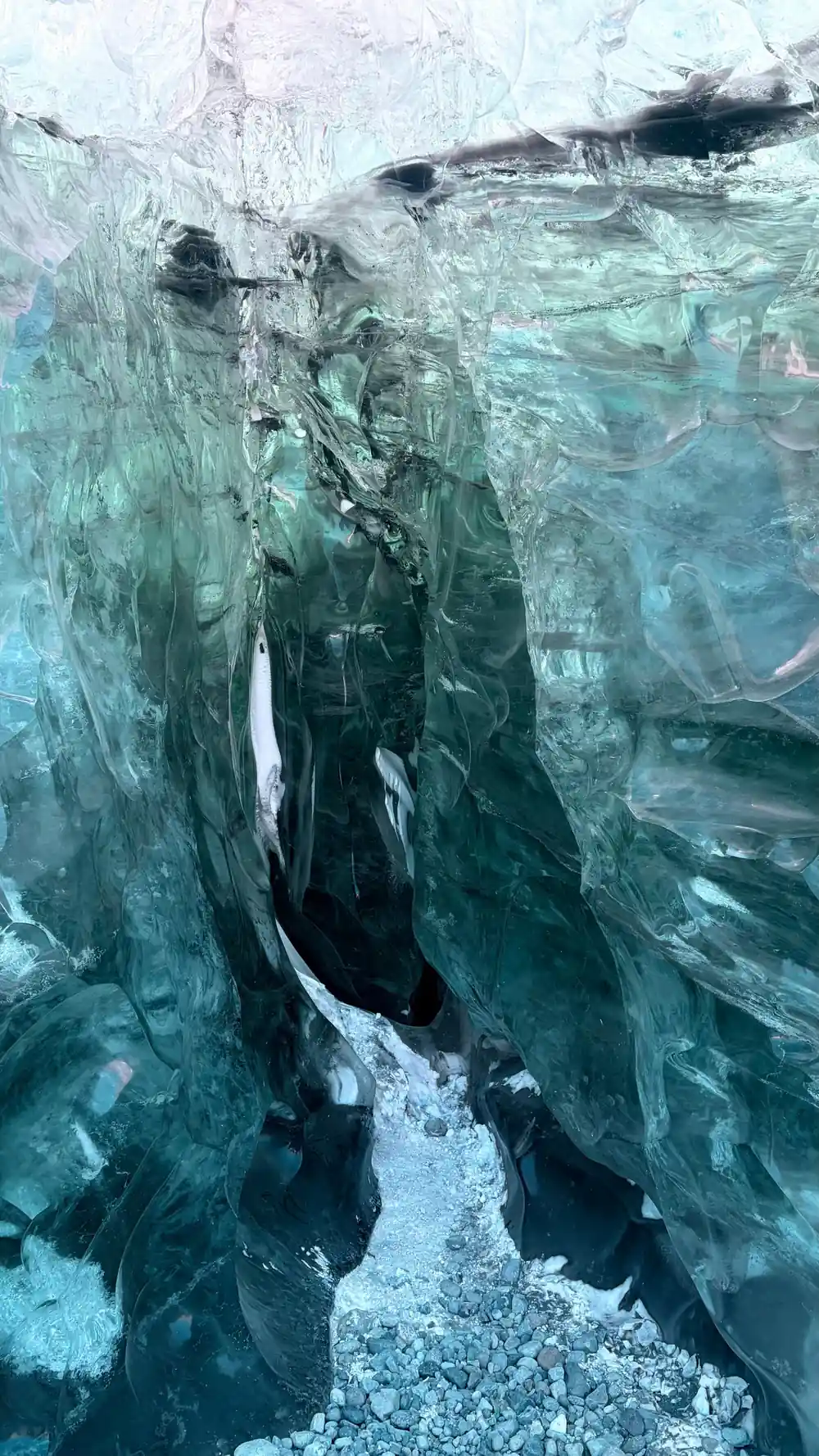 Inside ice cave with turquoise walls and crevasse