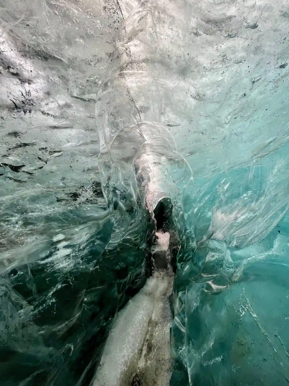 Person walking through narrow glacier ice passage