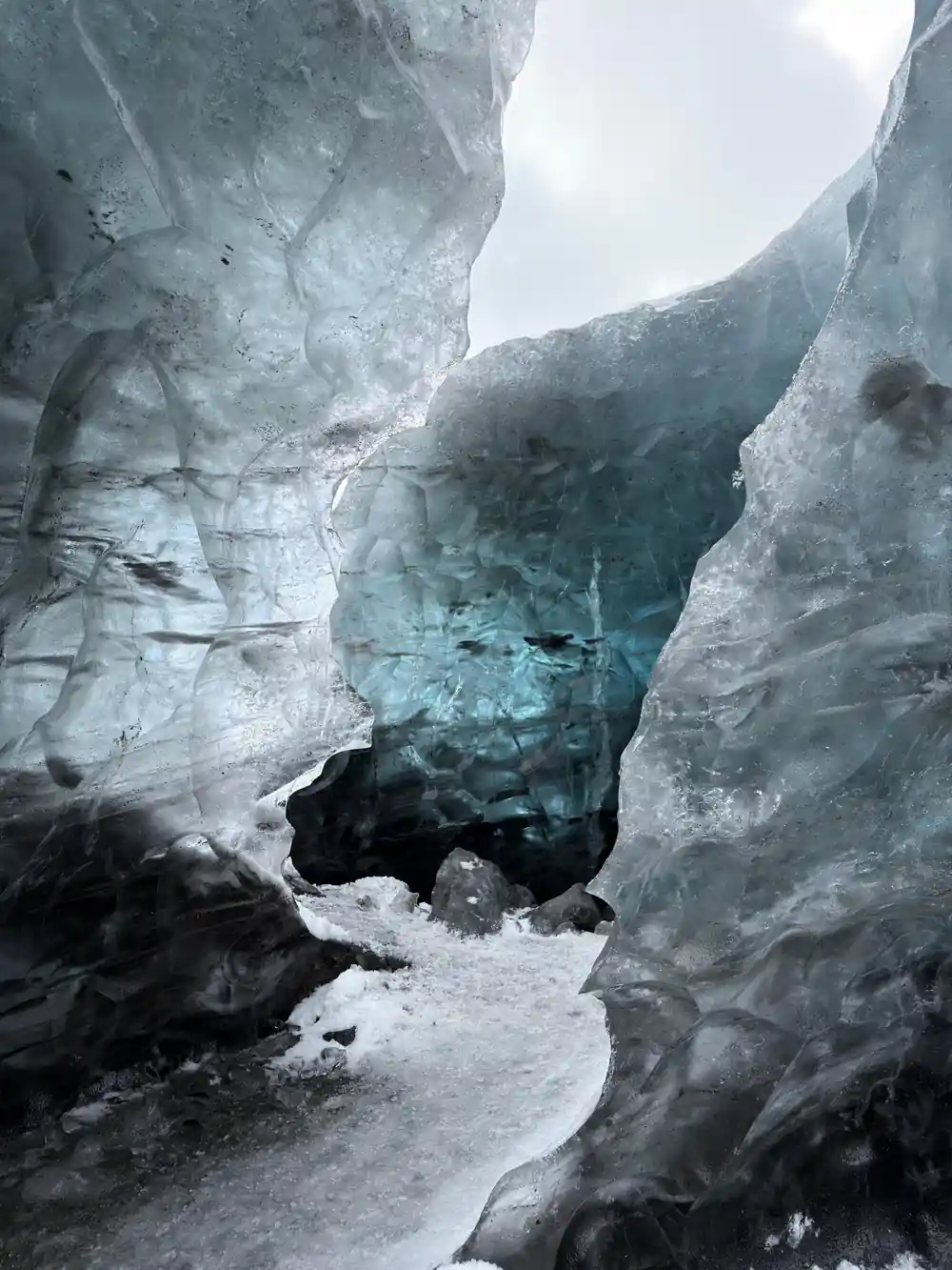 Tall ice cave tunnel walls with white-blue striations