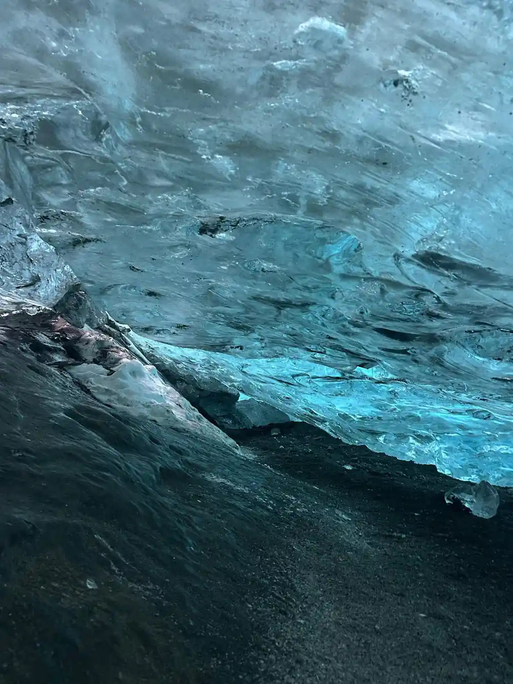 Turquoise and dark blue ice layers inside glacier cave