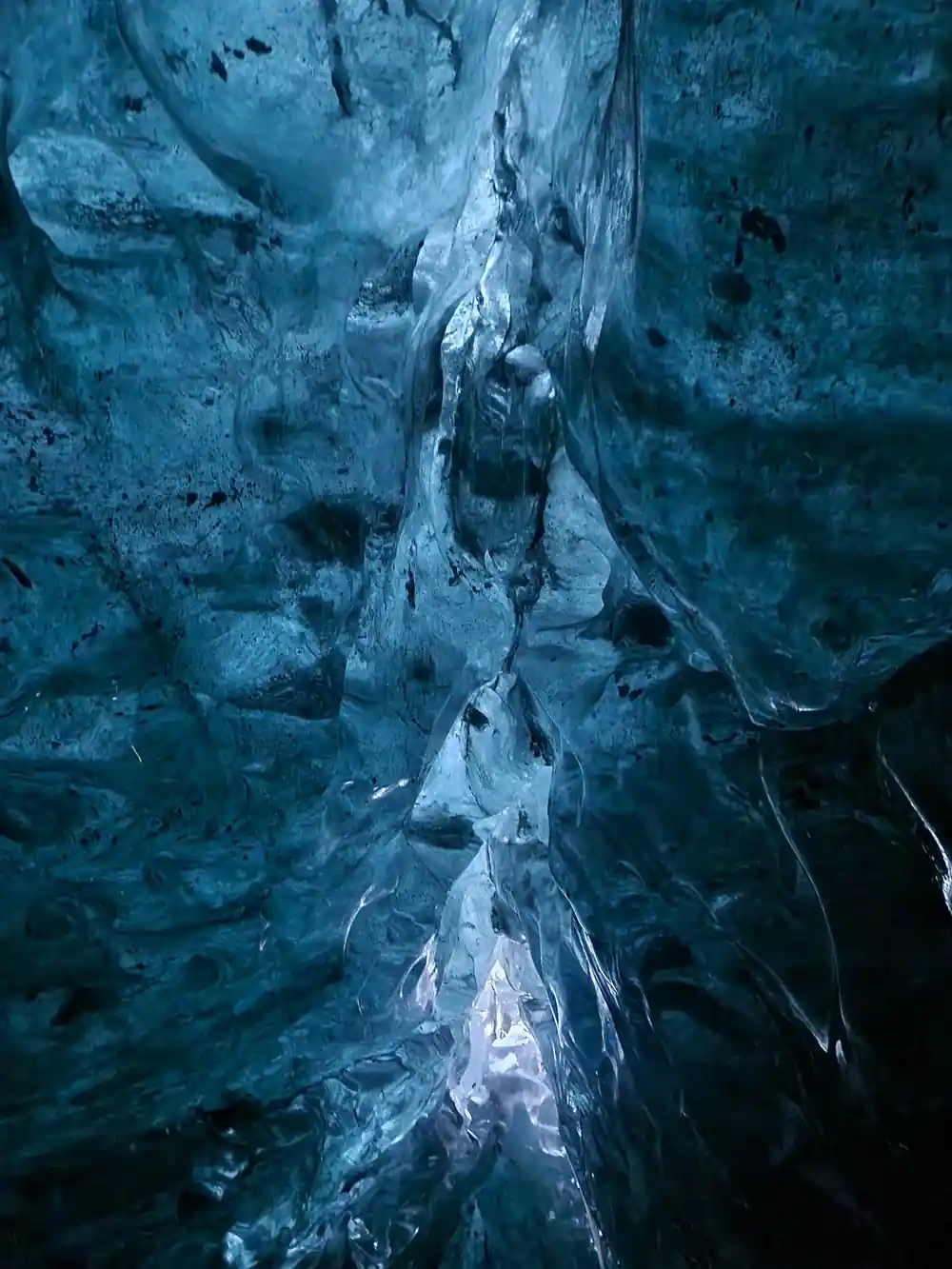 Vertical crevasse in dark blue glacial ice interior